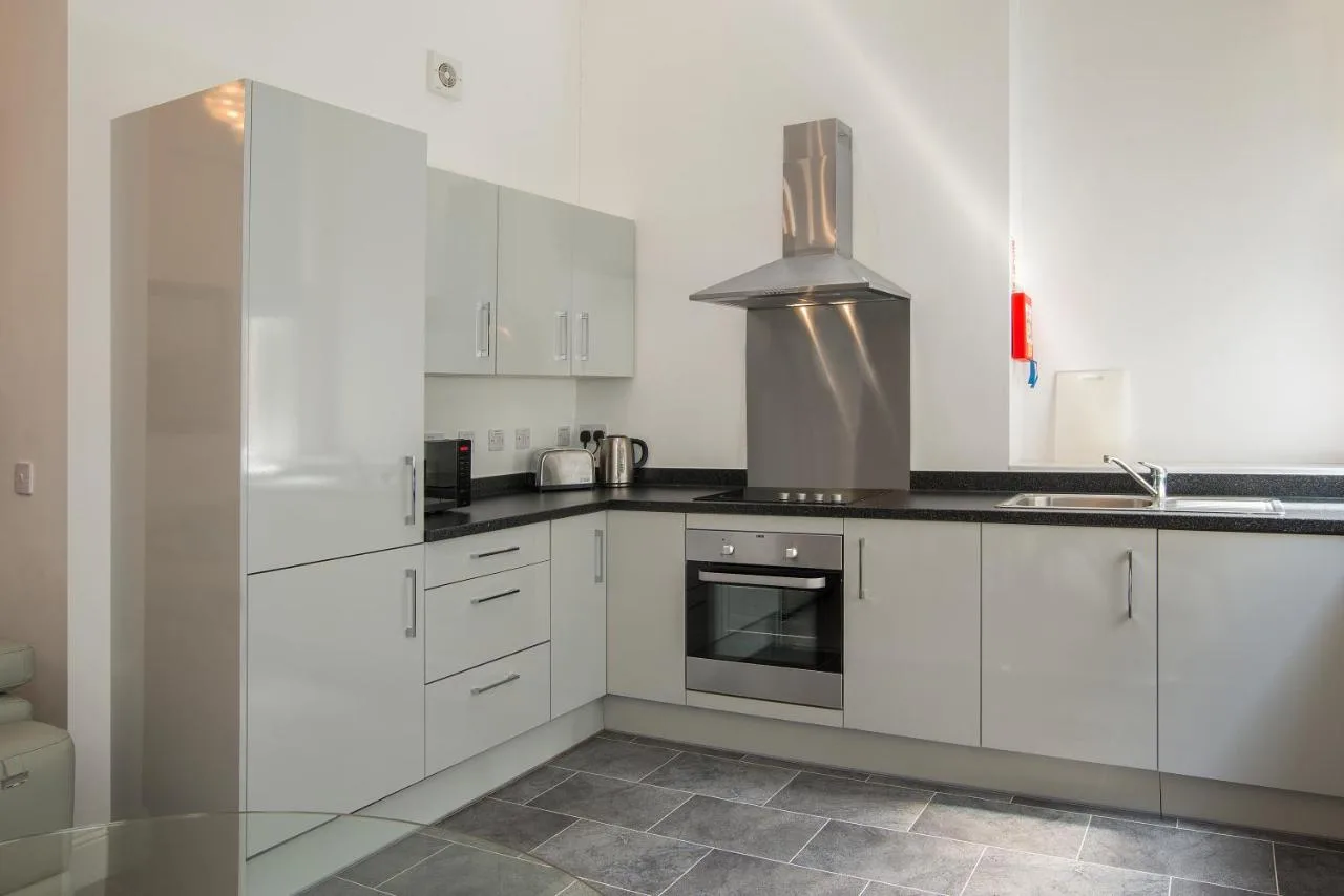 a kitchen with white cabinets and a stove at The Castle Collection 14 Cook Street in Liverpool