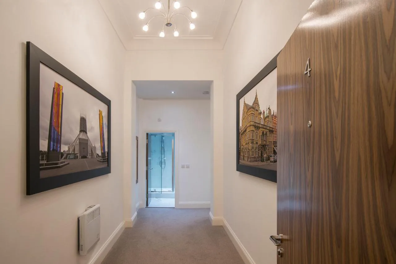 a hallway with paintings on the walls and a door at The Castle Collection 14 Cook Street in Liverpool